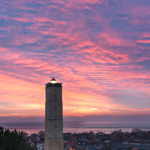 morgenrood op de achtergrond, de Brandaris in het dorp West geeft nog licht